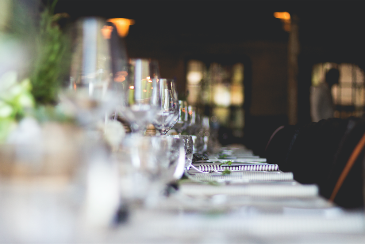 Wine glasses lined up on a table at a wedding reception